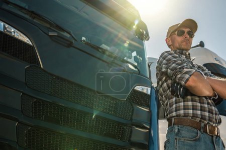 Photo for Semi truck driver standing by a truck with arms crossed staying next to his vehicle - Royalty Free Image