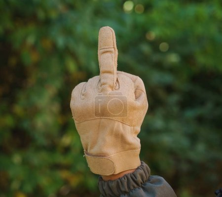 Photo for Gesture, morals and people concept - close up of man hands dressed in yellow tactical gloves showing middle finger hand sign. number one. Outdoor short of man fist with middle finger in gloves - Royalty Free Image