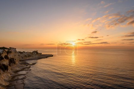 Téléchargez les photos : Paysage avec baie Saint Thomas au lever du soleil à Marsaskala, Malte - en image libre de droit