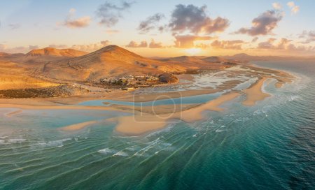 Téléchargez les photos : Playa de Sotavento au lever du soleil, Fuerteventura : une vue aérienne à couper le souffle sur des lagunes cristallines et des dunes de sable balayantes sur cette plage emblématique des Canaries. - en image libre de droit