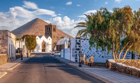Erleben Sie die heitere Schönheit der Kirche La Candelaria in La Oliva, Fuerteventura, eingebettet unter einem majestätischen Berg in einem historischen kanarischen Dorf.