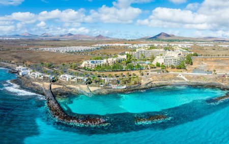 Téléchargez les photos : Surplombant la paisible Playa El Ancla à Costa Teguise, Lanzarote, où les eaux cristallines et les paysages volcaniques offrent une retraite pittoresque. - en image libre de droit