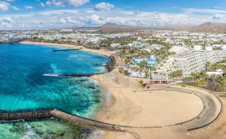 Téléchargez les photos : Playa de las Cucharas, Costa Teguise, Lanzarote : Une plage familiale parfaite avec sable doré, eaux turquoise et une variété de sports nautiques. - en image libre de droit