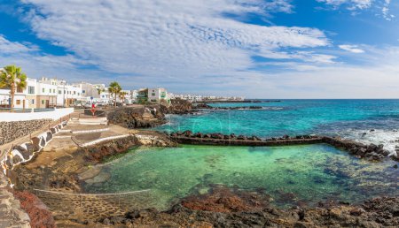 Téléchargez les photos : Punta Mujeres, Lanzarote : Un charmant village traditionnel avec des maisons blanches, des bateaux de pêche et une vue imprenable sur l'océan. - en image libre de droit