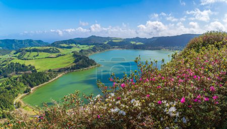 Blicken Sie vom Miradouro do Pico do Ferro auf das lebhafte Grün des Sees von Furnas, ein atemberaubendes Zeugnis der Pracht des Vulkans Sao Miguel und der reichen Flora.