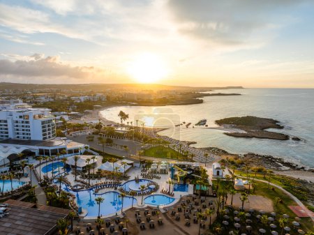 Foto de Disfrute de la salida del sol serena en Nissi Beach, Chipre, ideal para centros turísticos, tranquilas vistas al mar y viajes de placer. Un destino mediterráneo de primer nivel. - Imagen libre de derechos