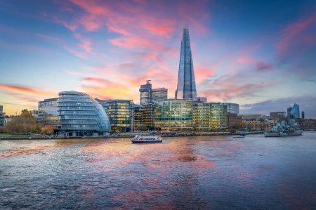 Entdecken Sie die atemberaubende Londoner Skyline mit dem Shard und der Themse. Dieses atemberaubende Bild fängt die Essenz moderner Architektur vor einem pulsierenden Sonnenuntergang ein. Ideal für Reisende und Stadtbild-Enthusiasten.
