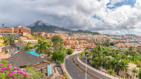 Explore the vibrant Adeje coast in Tenerife, showcasing lush landscapes, Mediterranean architecture, and mountain views. Ideal for travel and vacation themes.