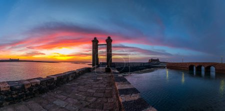 Téléchargez les photos : La promenade Arrecife à Lanzarote offre une vue imprenable sur l'océan au coucher du soleil, des lampadaires et une atmosphère romantique idéale pour des promenades relaxantes. - en image libre de droit