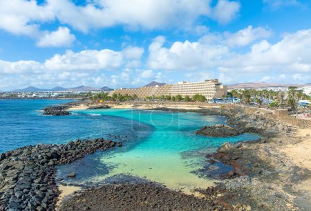 El Jablillo idílicas aguas, un refugio de snorkeler en Costa Teguise, Lanzarote, enmarcado por rocas volcánicas y vibrante vida marina.