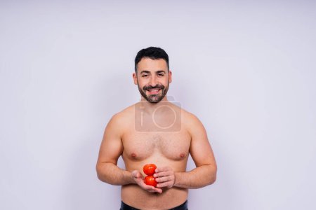 Photo for Full isolated studio picture from a young naked man with underwear and tomatoes - Royalty Free Image
