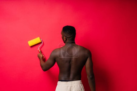 Photo for African-American painter on a red studio background topless - Royalty Free Image