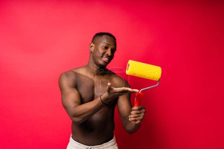 Photo for African-American painter on a red studio background topless - Royalty Free Image