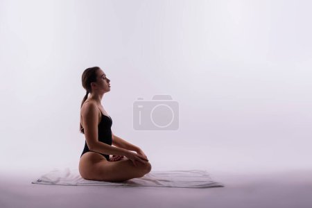Téléchargez les photos : Belle femme faisant des poses sur un cours de yoga. Plan studio. - en image libre de droit