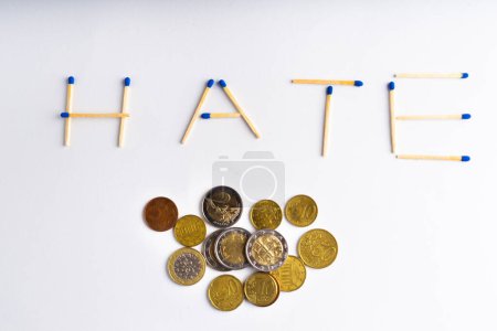Téléchargez les photos : Le mot haine des allumettes de feu de bois avec une monnaie en euros pièces et calculatrice - en image libre de droit