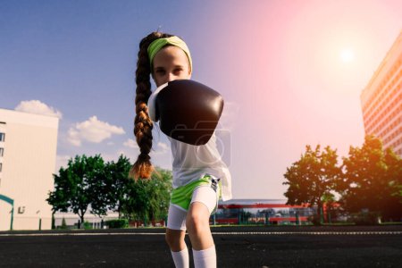 Foto de Mujer boxeadora infantil en guantes, concepto feminista. Regreso a la escuela, entrenamiento físico. - Imagen libre de derechos