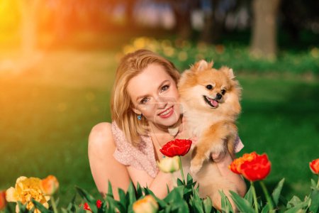 Photo for Close up portrait of smiling young attractive woman embracing Pomeranian spitz. - Royalty Free Image