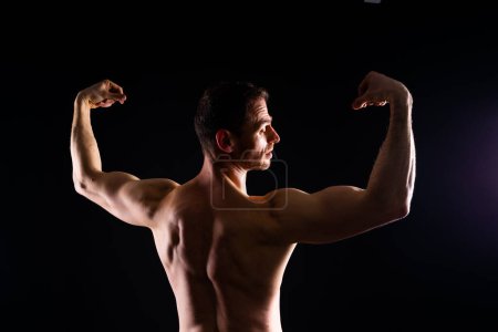 Photo for Handsome bodybuldier man posing showing muscle, shirtless torso showing pectorals and sixpacks - Royalty Free Image