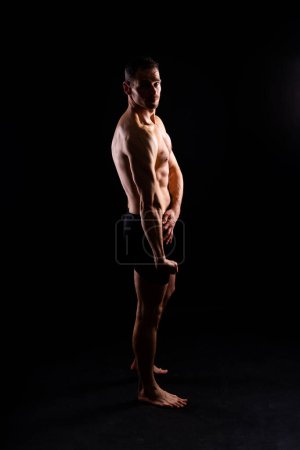 Photo for Handsome bodybuldier man posing showing muscle, shirtless torso showing pectorals and sixpacks - Royalty Free Image
