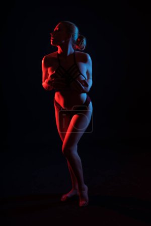 Low key portrait of beautiful female body on a dark background