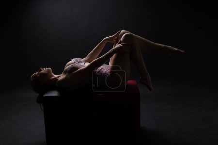 Low-Key-Porträt des schönen weiblichen Körpers auf dunklem Hintergrund