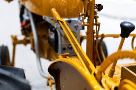 Detail eines kleinen Traktors mit gelben Baufahrzeugen, Caterpillar Ten