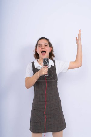 Avec microphone dans une main chanteuse adolescente positive, jeune chanteuse de karaoké tenir microphone.