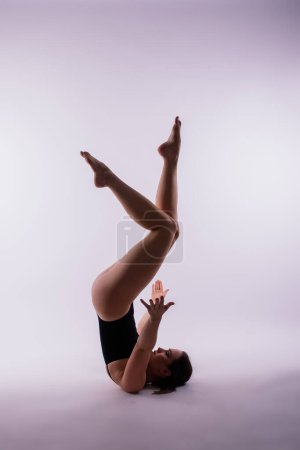 Hermosa mujer haciendo poses en una clase de yoga. Captura de estudio.