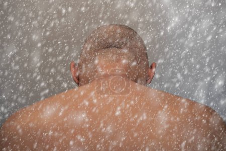 Foto de Afeitado hombre desnudo visto por detrás entra en tormenta de nieve - Imagen libre de derechos