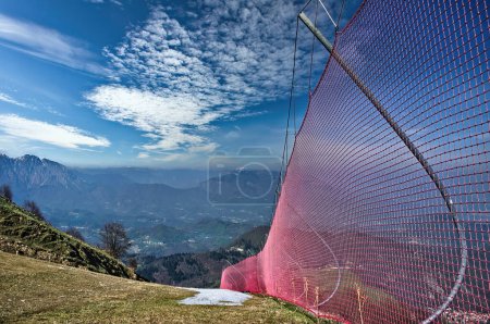 Foto de Pista de esquí en las montañas. En el lateral, se instalan redes de seguridad rojas - Imagen libre de derechos