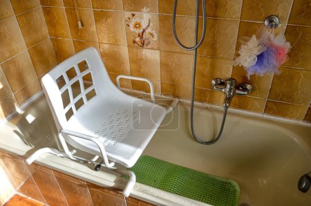 Foto de Silla giratoria colocada en la bañera para uso de personas con discapacidad y personas mayores con dificultad para caminar para entrar en la bañera - Imagen libre de derechos
