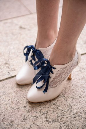 Foto de Zapatos de mujer blancos con cordones azules y encaje, en los pies de una mujer - Imagen libre de derechos