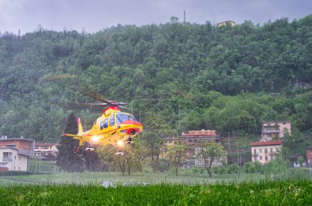 Notarzthubschrauber hebt bei starkem Regen während eines schweren Gewitters vom Hubschrauberlandeplatz eines Krankenhauses ab