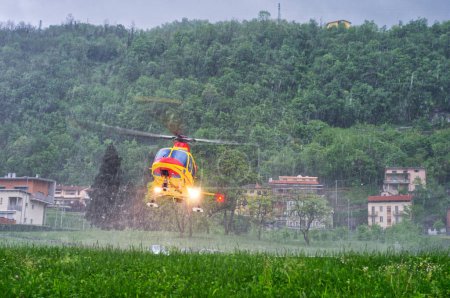 Notarzthubschrauber hebt bei starkem Regen während eines schweren Gewitters vom Hubschrauberlandeplatz eines Krankenhauses ab