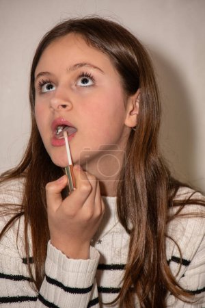 Foto de Adolescente tratando con sus primeros trucos de maquillaje facial - Imagen libre de derechos