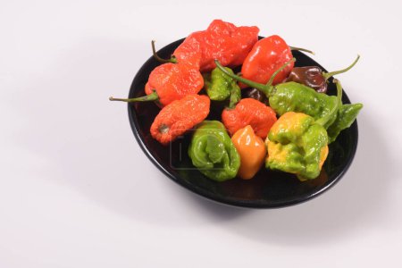 Foto de Chile peppers Capsicum chinense on black plate - Imagen libre de derechos