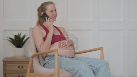 Téléchargez les photos : Pregnant Woman Talking on Phone at Home - en image libre de droit