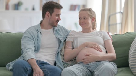 Téléchargez les photos : Pregnant Woman and Husband Talking with Each other at Home - en image libre de droit