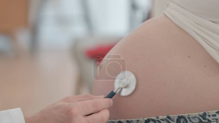 Photo for Doctor Listening Pregnant Belly of Woman with Stethoscope - Royalty Free Image