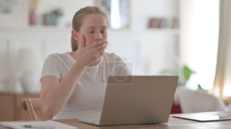 Foto de Mujer joven reaccionando a la pérdida mientras usa el ordenador portátil - Imagen libre de derechos