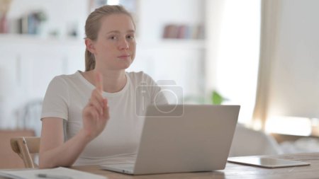 Téléchargez les photos : Rejecting Young Woman Waving Finger in Denial while using Laptop - en image libre de droit