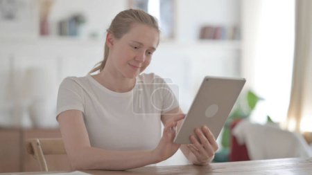 Foto de Mujer joven usando Tablet mientras está sentada en la oficina - Imagen libre de derechos