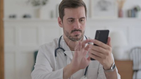 Photo for Portrait of Male Doctor using Smartphone - Royalty Free Image