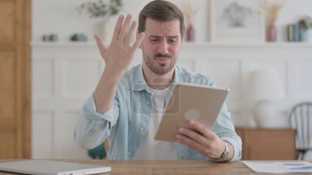 Photo for Casual Man Reacting to Loss on Tablet in Office - Royalty Free Image