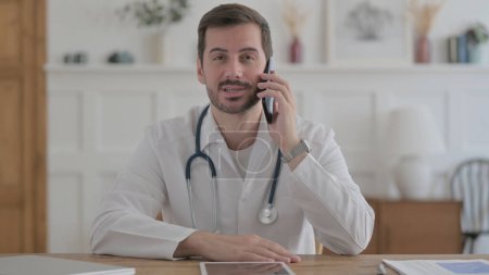 Téléchargez les photos : Male Doctor Talking on Phone in Clinic - en image libre de droit
