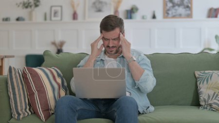 Téléchargez les photos : Casual Man with Laptop having Headache on Sofa - en image libre de droit