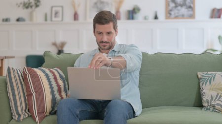 Photo for Casual Man Siting on Sofa, Opening Laptop - Royalty Free Image