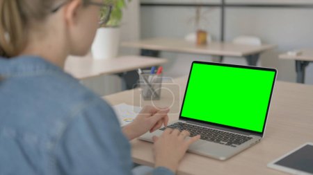 Téléchargez les photos : Belle femme travaillant sur ordinateur portable avec écran chroma vert - en image libre de droit