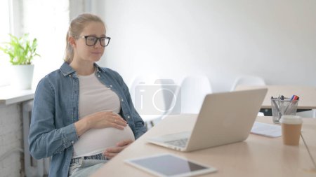 Photo for Happy Pregnant Beautiful Woman Watching Video on Laptop - Royalty Free Image
