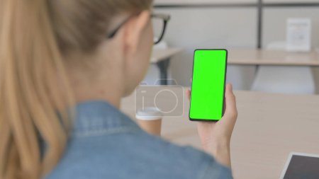 Téléchargez les photos : Belle femme regardant Smartphone avec écran Chroma vert - en image libre de droit